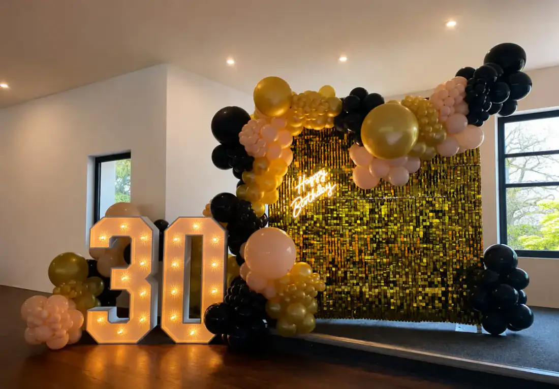 Gold shimmer wall with 30 light up numbers and balloon garland