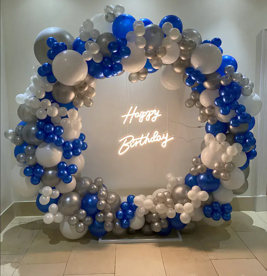 Blue silver and white birthday hoop backdrop with neon sign