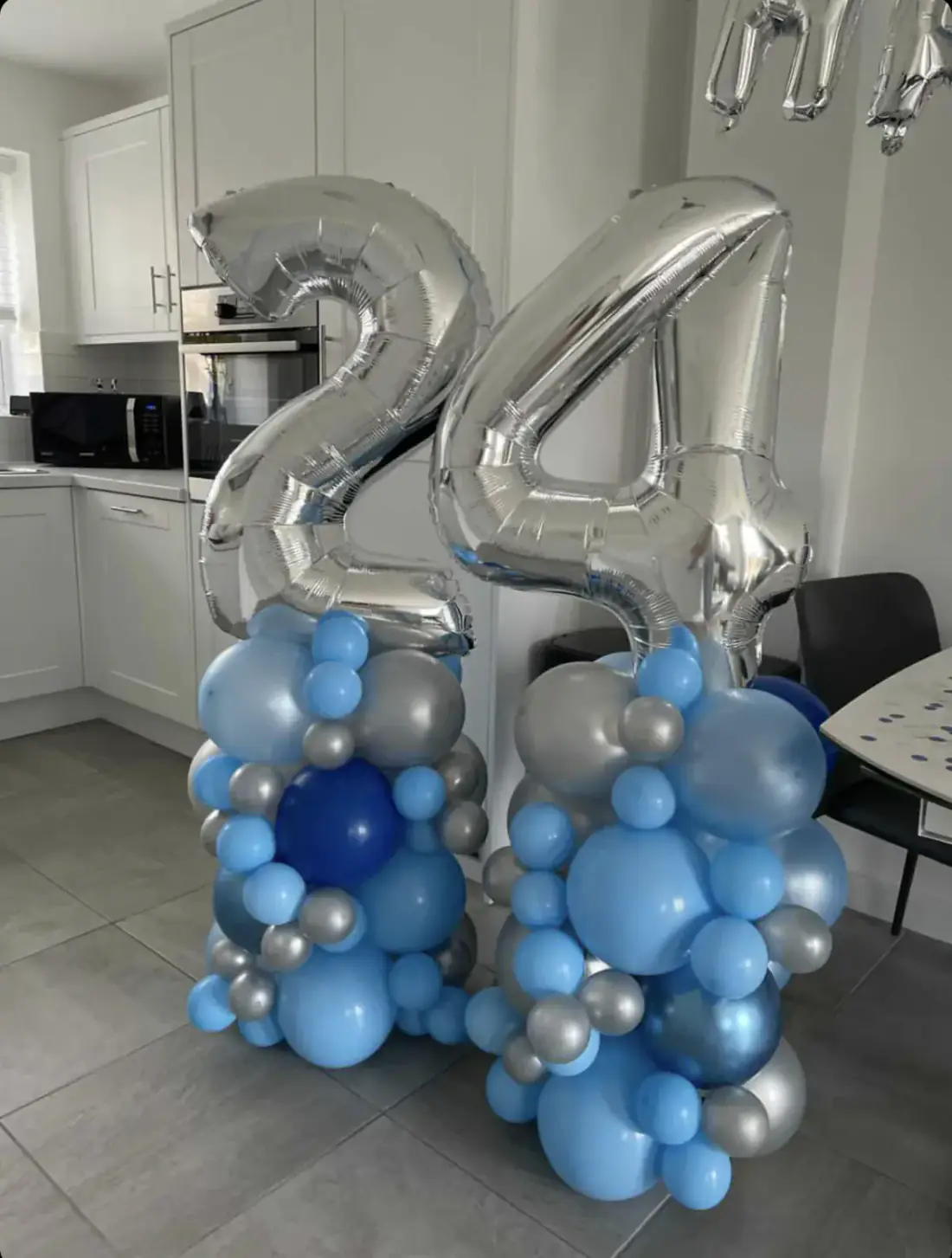 Silver 24 number balloons on blue bubble balloon columns