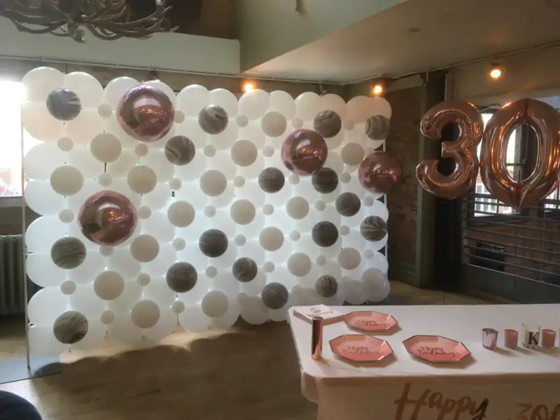 Rose gold 30th birthday balloon wall with table styling