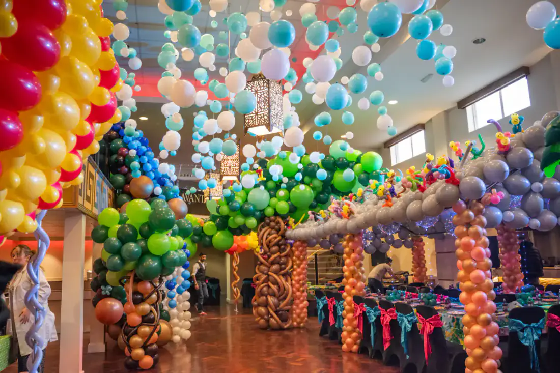 1st birthday rain forest balloon canopy with balloon trees and party tables