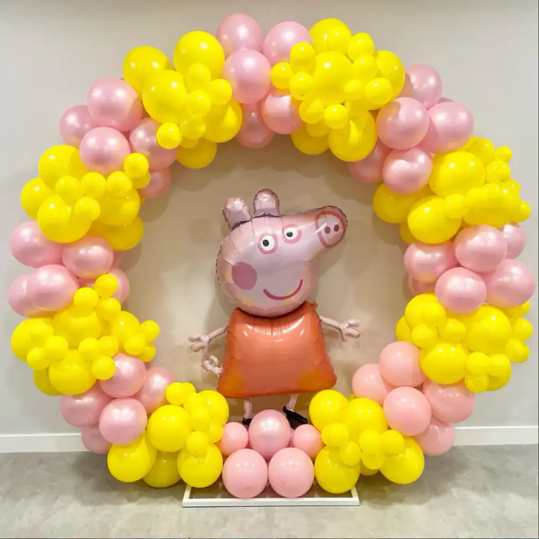 Pink and yellow balloon ring with Peppa Pig character