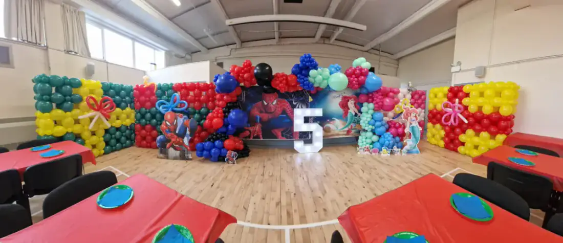 Wide superhero party wall with balloon garland and light up number five