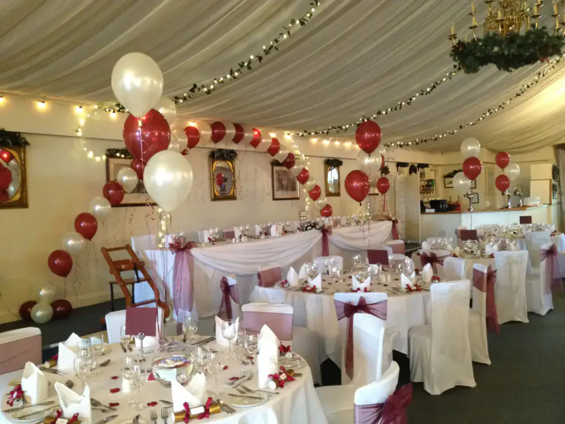 Wedding venue with red and ivory table balloons