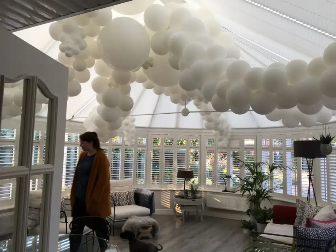 White balloon ceiling cloud installation in a bright wedding room