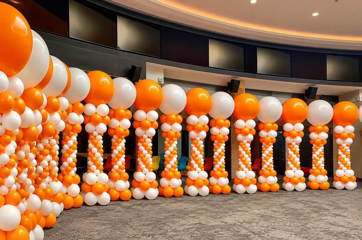 Orange and white balloon divider installation in an event venue