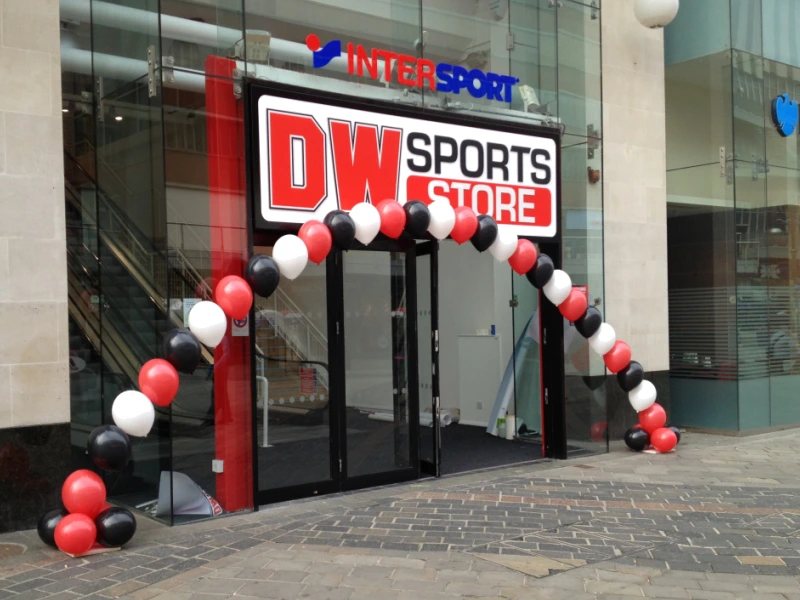 Black, red and white balloon arch outside DW Sports store