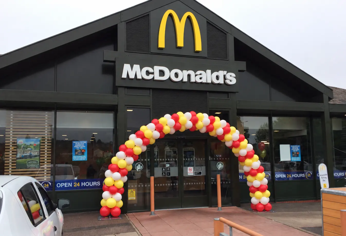 Red, yellow and white balloon arch outside McDonald's entrance