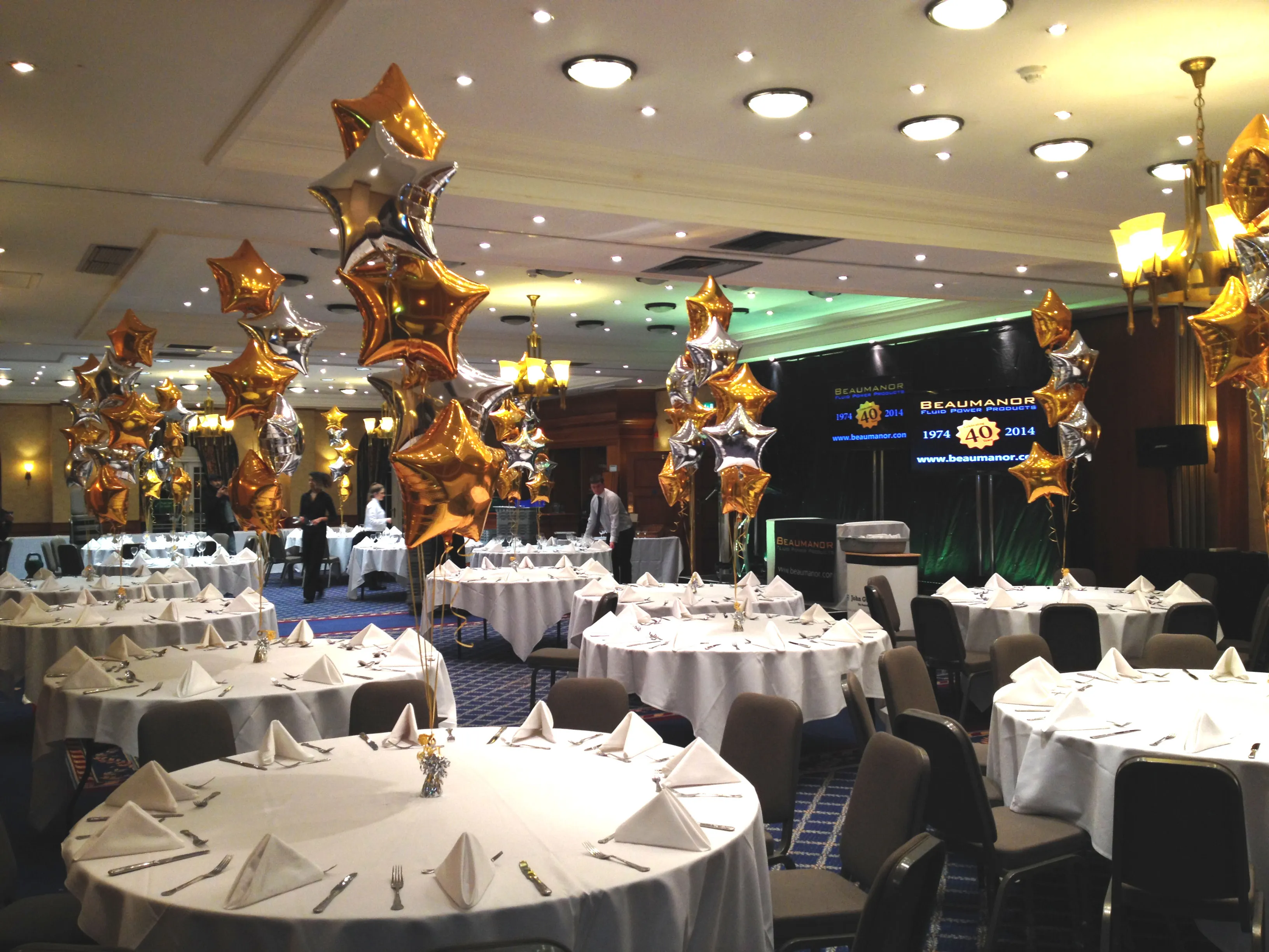 Corporate dining room with metallic star balloon table centrepieces