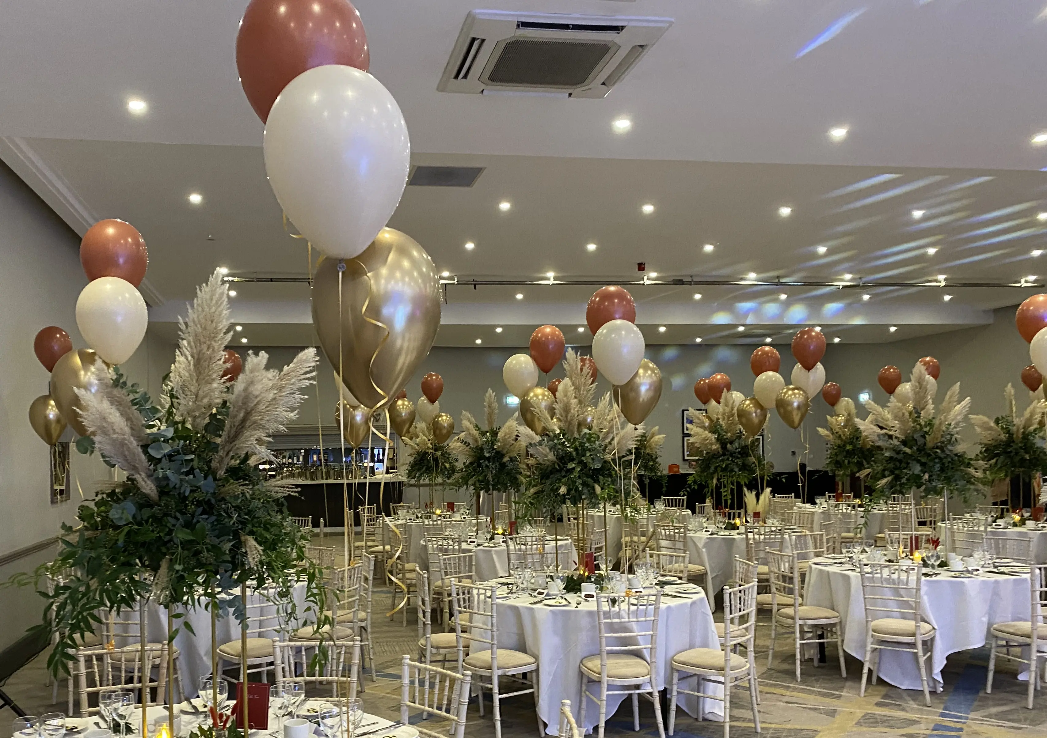 Corporate dinner venue with neutral balloon table centrepieces